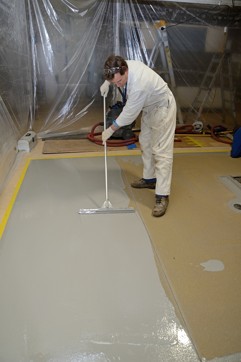 Man applying epoxy coating to floor